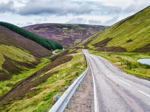 The Lecht Road makes its way through heather-clad mountains