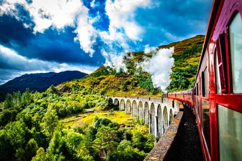 View along the side of the Jacobite Steam train to the locomotive as it crosses the Glenfinnan Viaduct heading towards Ben Nevis