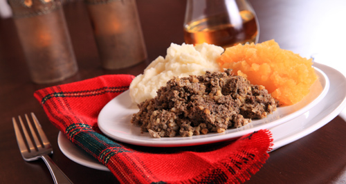 Traditional Haggis, Neeps and Tatties served by candle light on a tartan dressed table