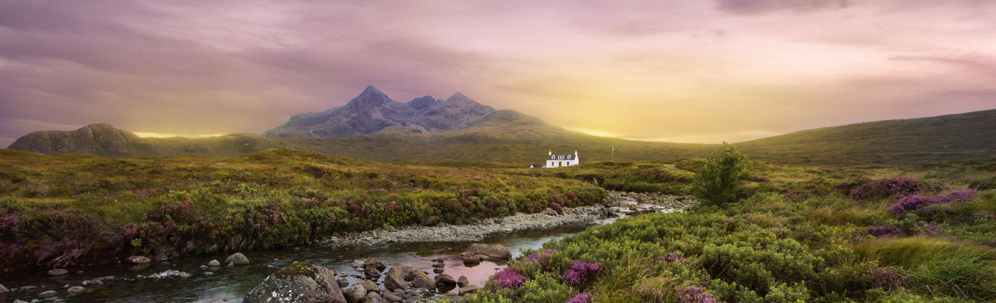 Lagangarbh Cottage sits by the River Coupal and is surrounded by heather with the mountains of Glen Coe in the background