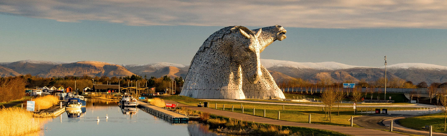Kelpies horse-head statues towering above boats on the Forth and Clyde Canal
