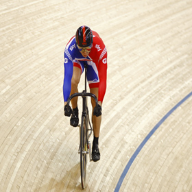 Sir Chris Hoy - cycling in red, white and blue colours in indoor arena
