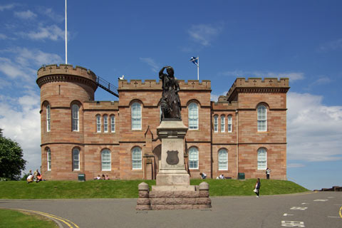 Flora MacDonald Statue - statue of young woman with arm raised, in front of Inverness Castle