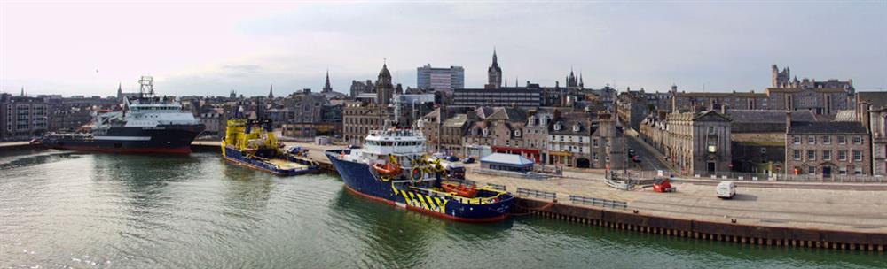panoramic view of ships and vessels docked at Aberdeen Harbour with the city in the background