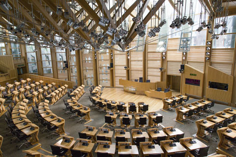 desks arranged in concentric semi-circles inside the Scottish Parliament